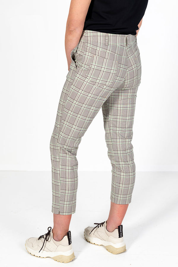 Woman wearing green, stone and black checkered golf pants 

