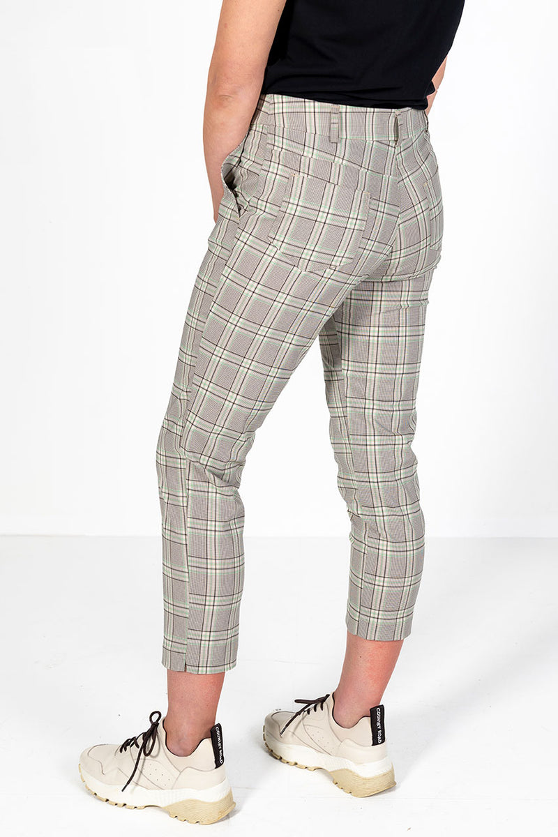 Woman wearing green, stone and black checkered golf pants 
